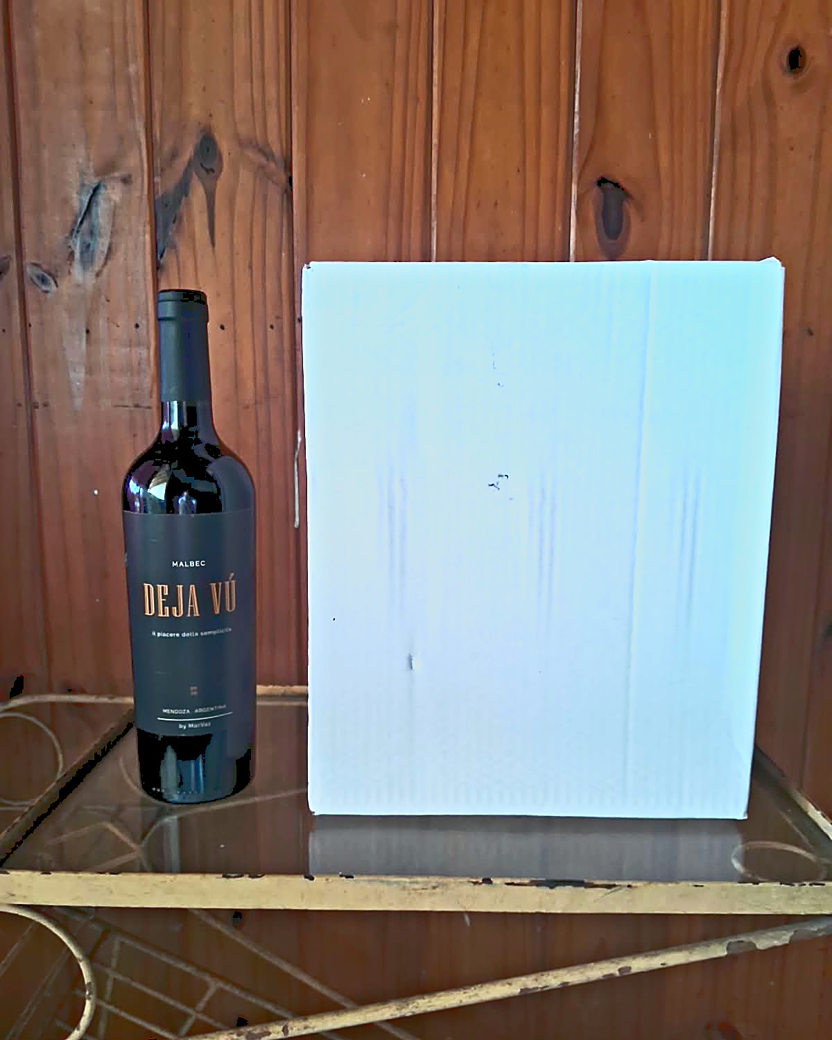 La caja cerrada de seis botellas junto a una botella de Deja V&uacute; Malbec